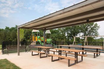 Two playgrounds with picnic tables